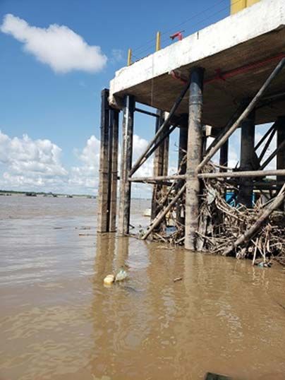 Concrete pier on piles over the brown water of the Ucayali river