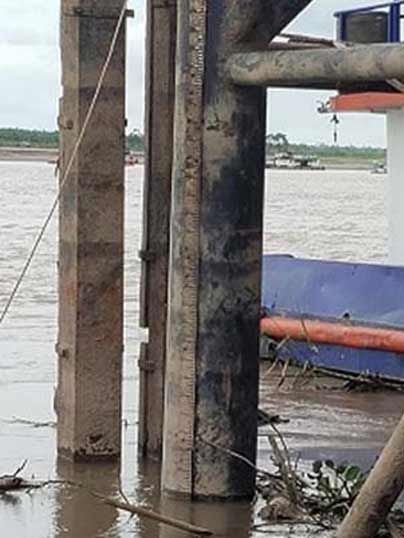 Piles of the pier in the Ucayali river with a cable running down to the water