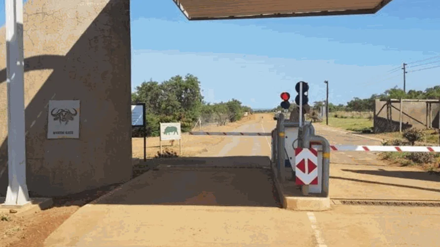 Entrance lane at Dinokeng Game Reserve with a boom barrier, a traffic light and the gate pedestal