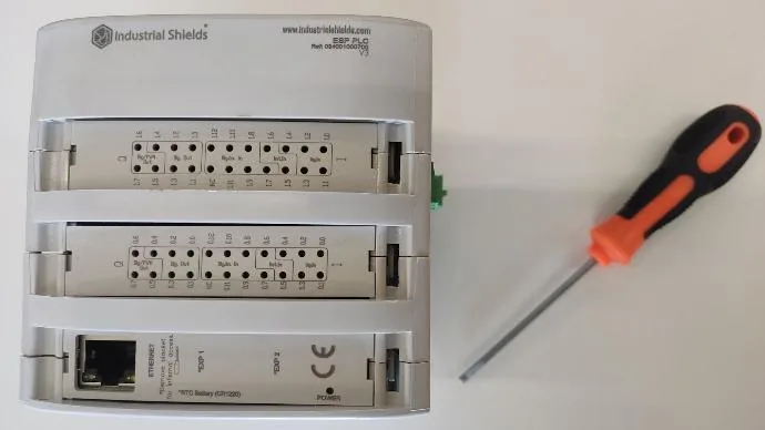 Front of an ESP32 PLC V3 with the Ethernet port cover in place and a flat screwdriver to lift it